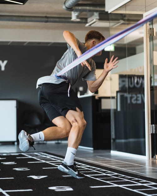 Sportler springt über eine Markierung auf dem Trainingsboden