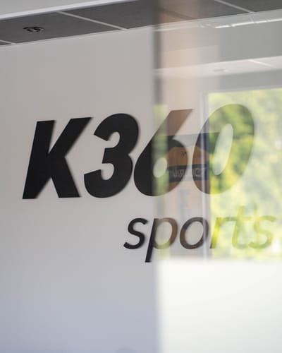 Schriftzug „K360 sports“ auf einer Glaswand im KINGS360-Center